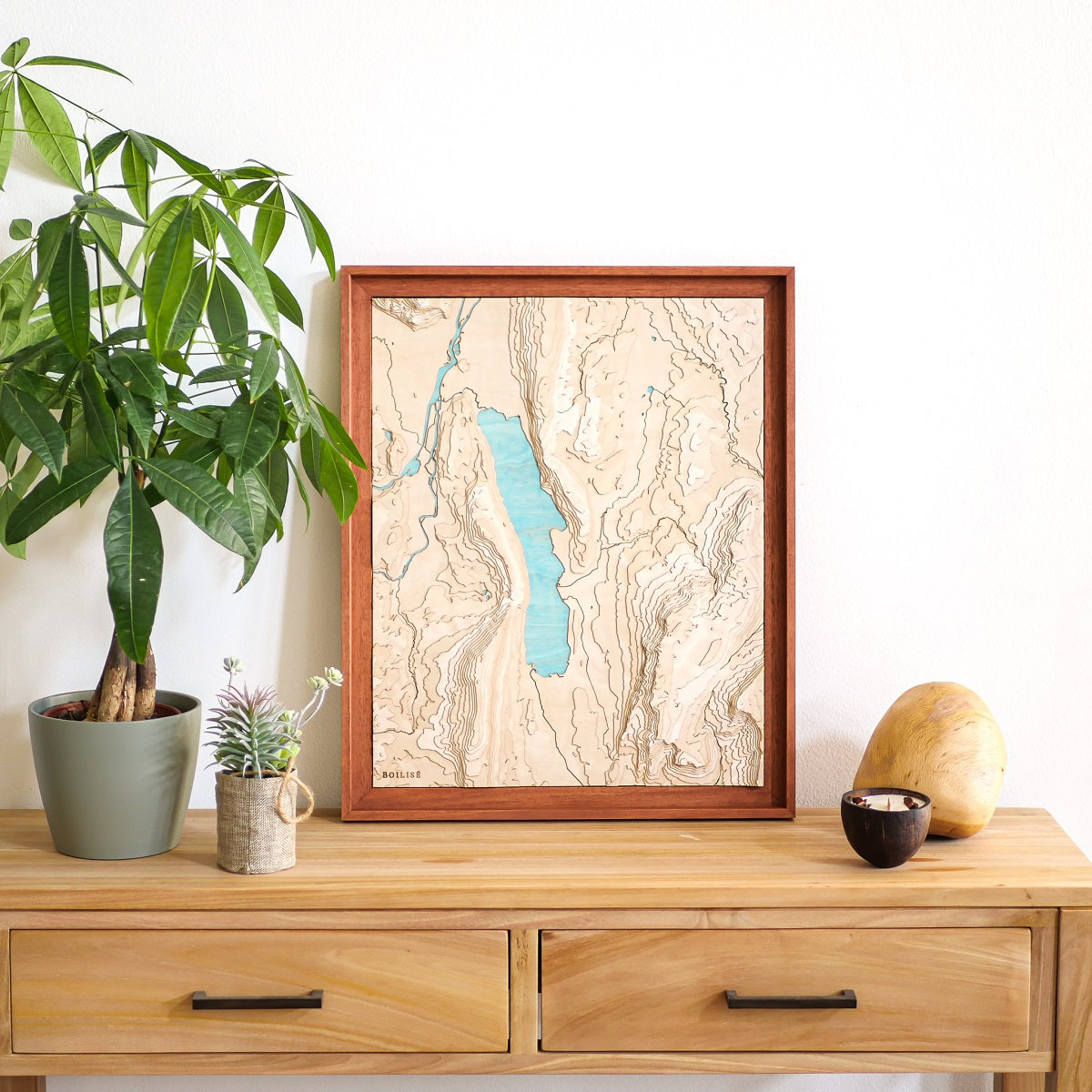 Tableau du lac du Bourget posé sur une commode en bois